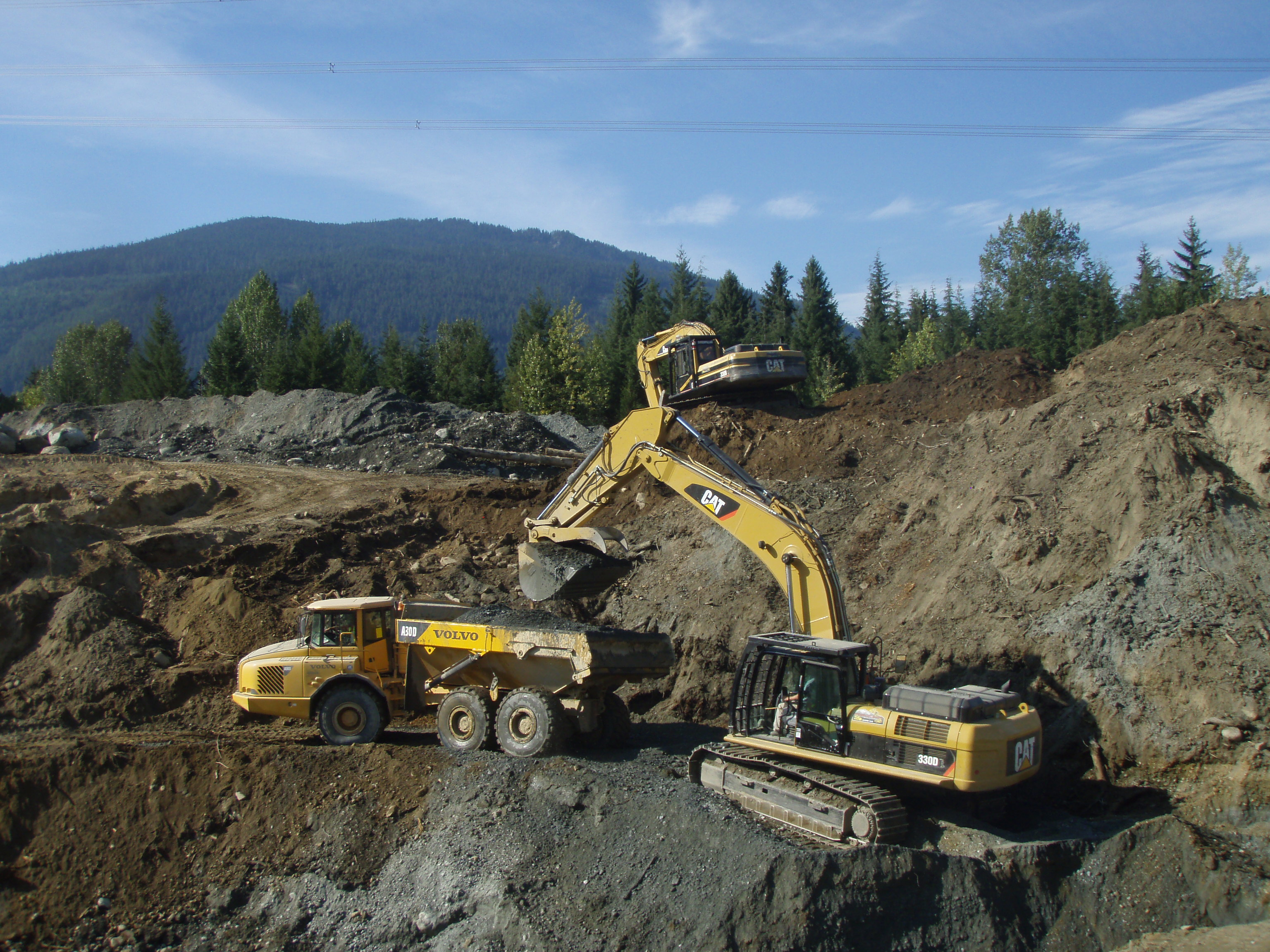 CAT 330D excavator loading Volvo A30D articulated dump truck major earthworks