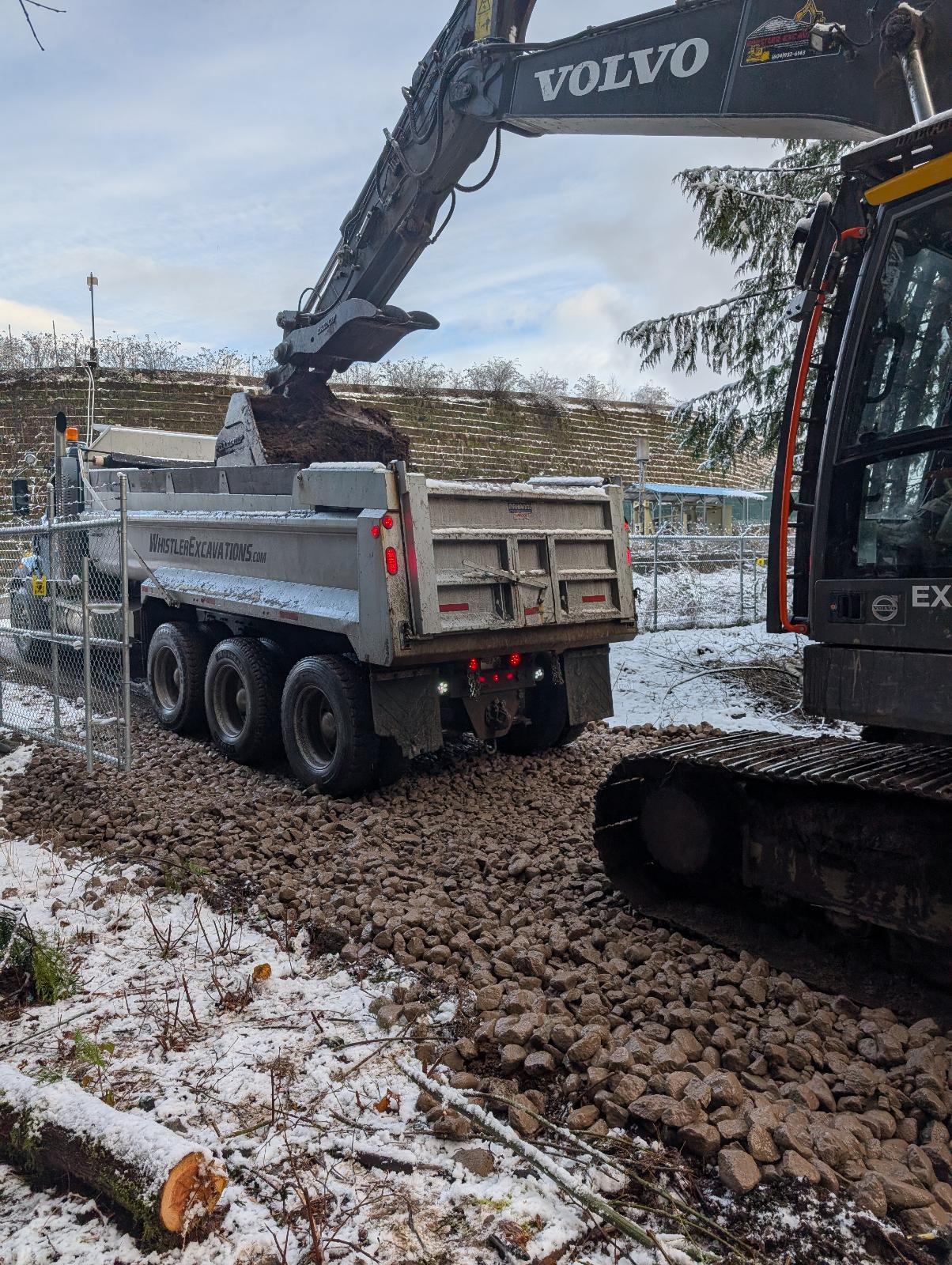 Whistler Excavations Volvo excavator loading dump truck landfill access winter