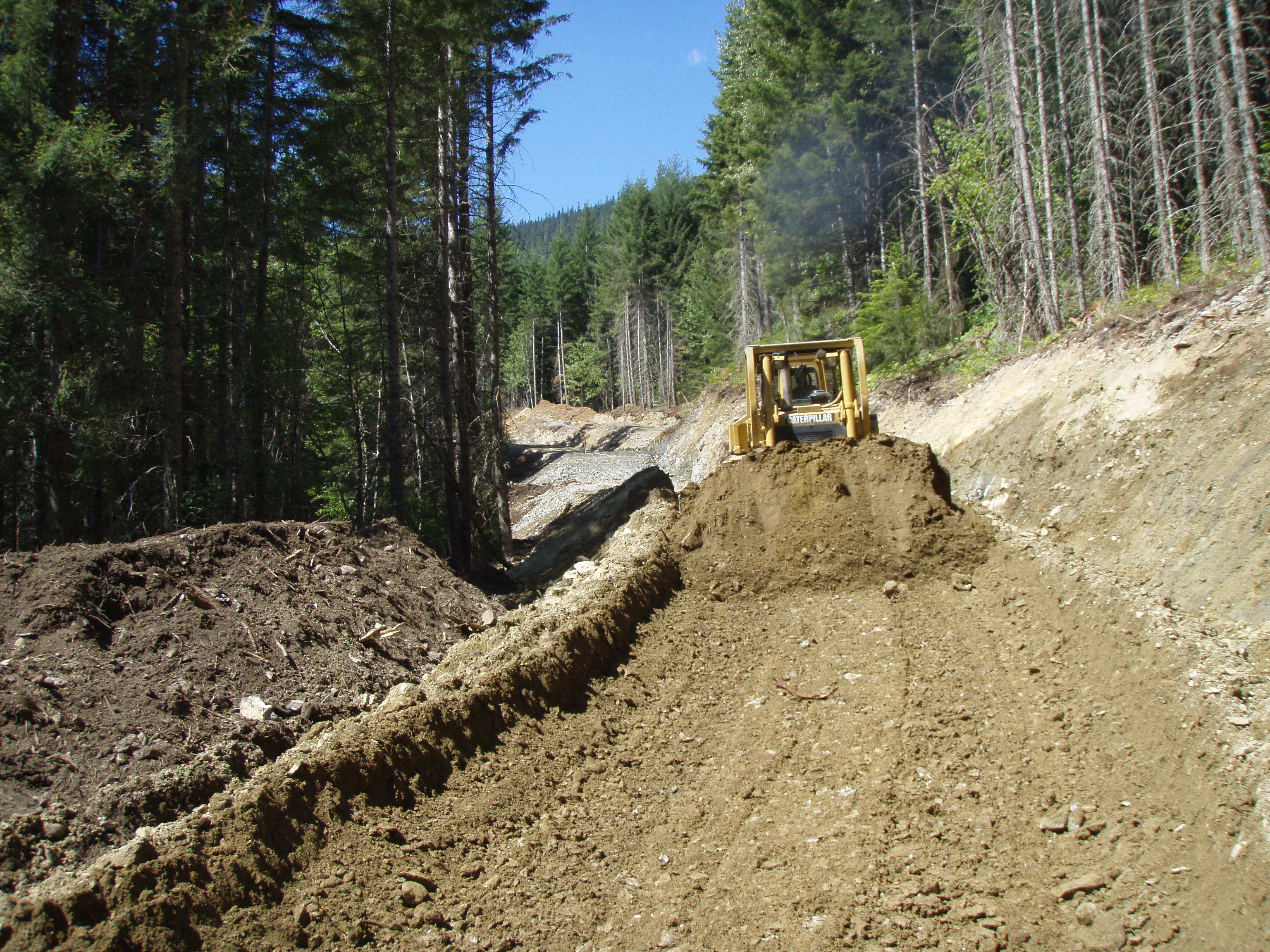 CAT bulldozer cutting new road through forest Sea to Sky