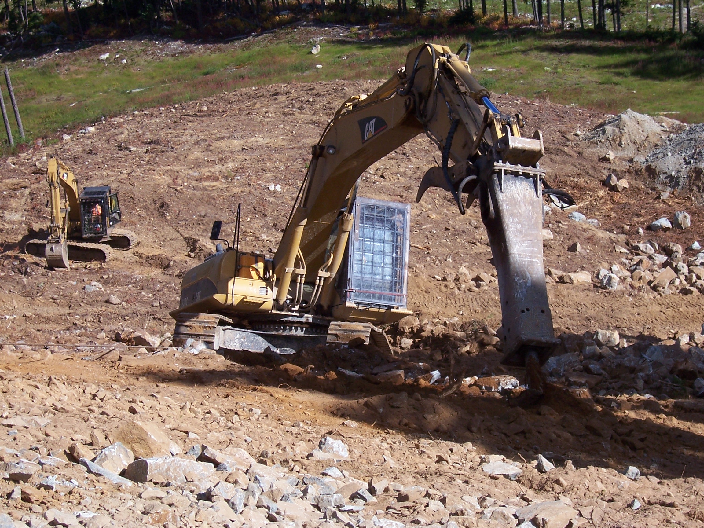 Two CAT excavators with rock hammers alpine clearing Whistler